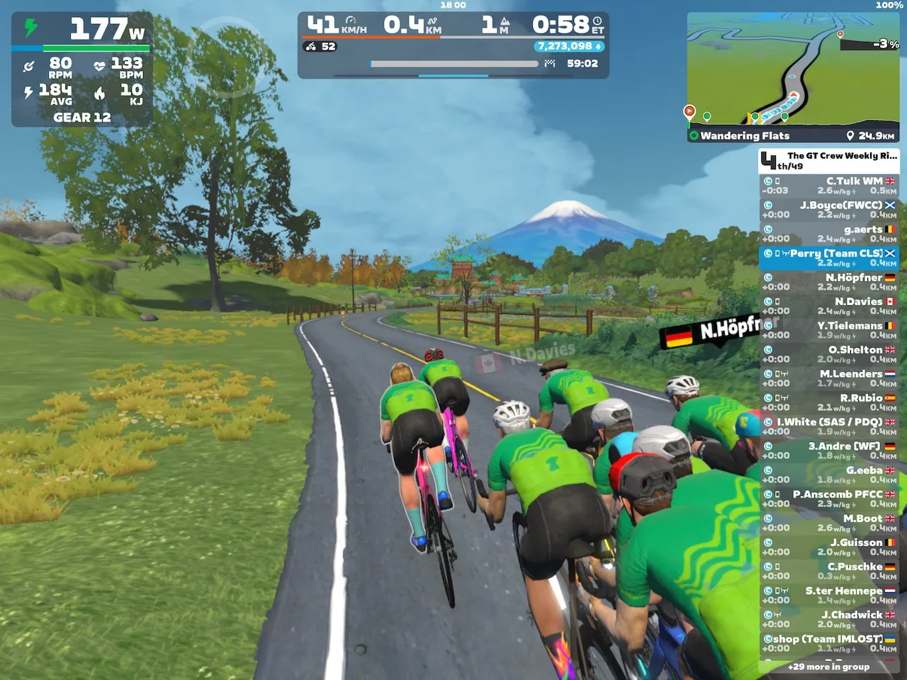 Riders avatars riding towards the conical Mount Fuji in Zwift's Makuri Islands world.