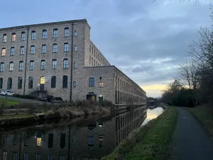 Evening view past Northlight Mill towards Burnley with the mill reflecting on the still canal.