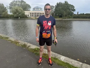 Me standing infront of the Wylam Brewery, with a lake in-between, ahead of the Great North Run in 2025