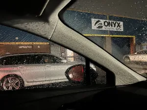 View through rain drenched window to the outside of Onyx climbing wall in Blackburn