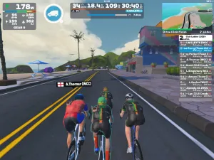 Cyclists avatars riding together in front of colorful houses on Zwift