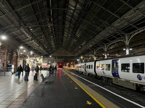 Looking along the platform at Preston Railway Station towards Starbucks, illuminated by street lighting early morning.